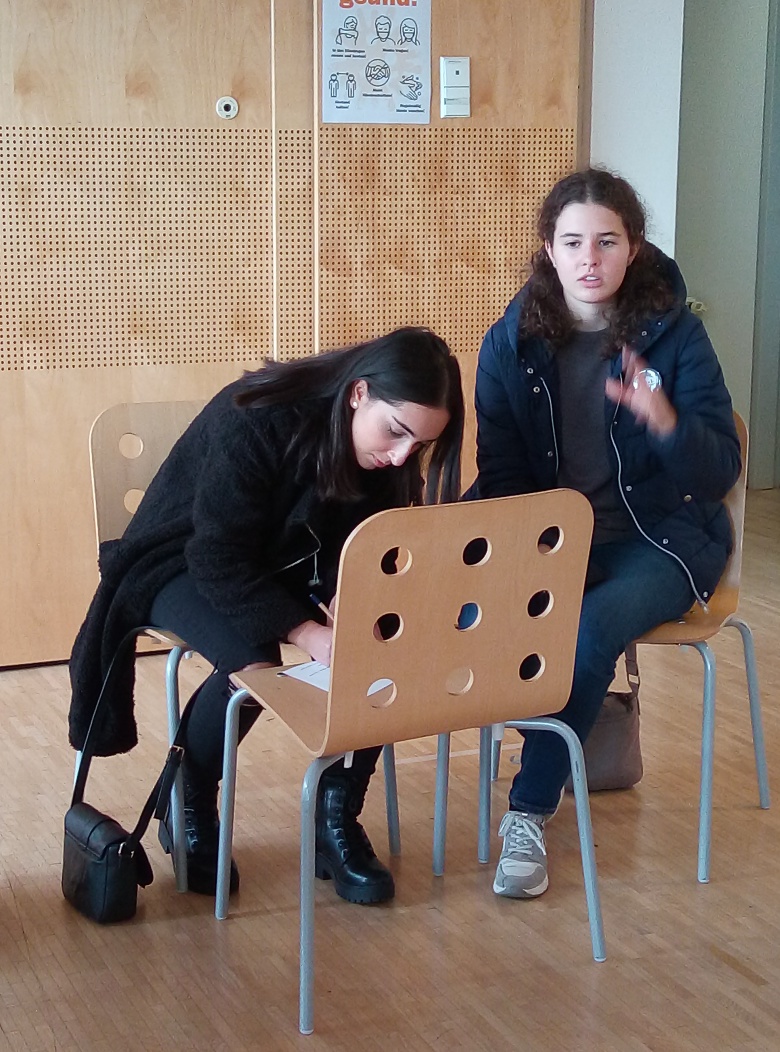 Zwei Mädchen sitzen nebeneinander und besprechen ein Thema