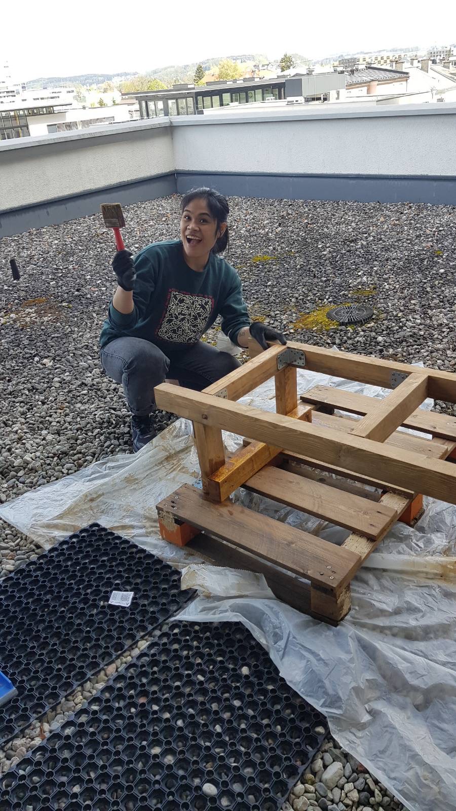junge Frau lasiert Bienenstand, Bienenstandbau-Aktion akzente Salzburg 