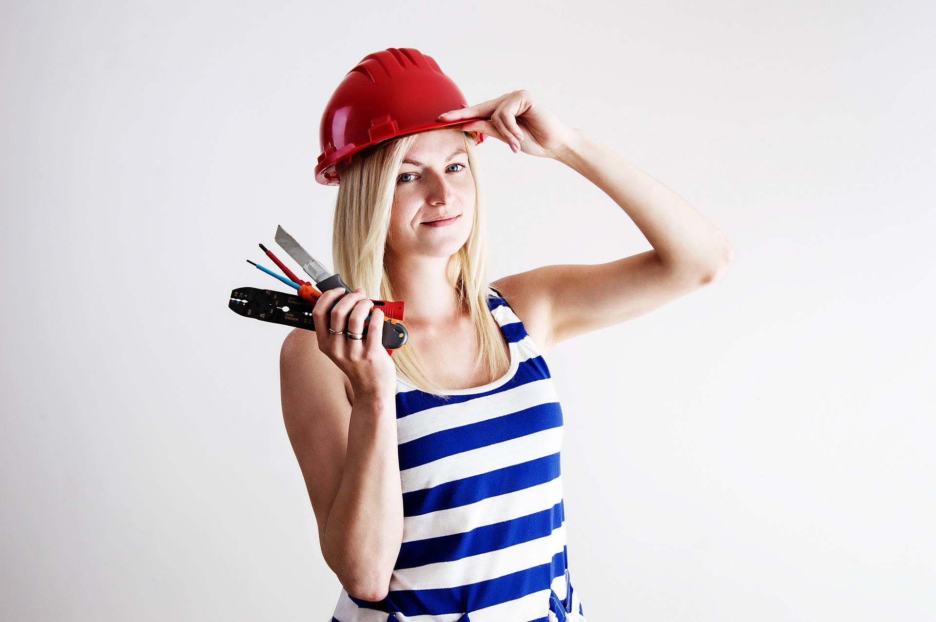 junge Frau mit Arbeitshelm und Werkzeug - Ferialjob