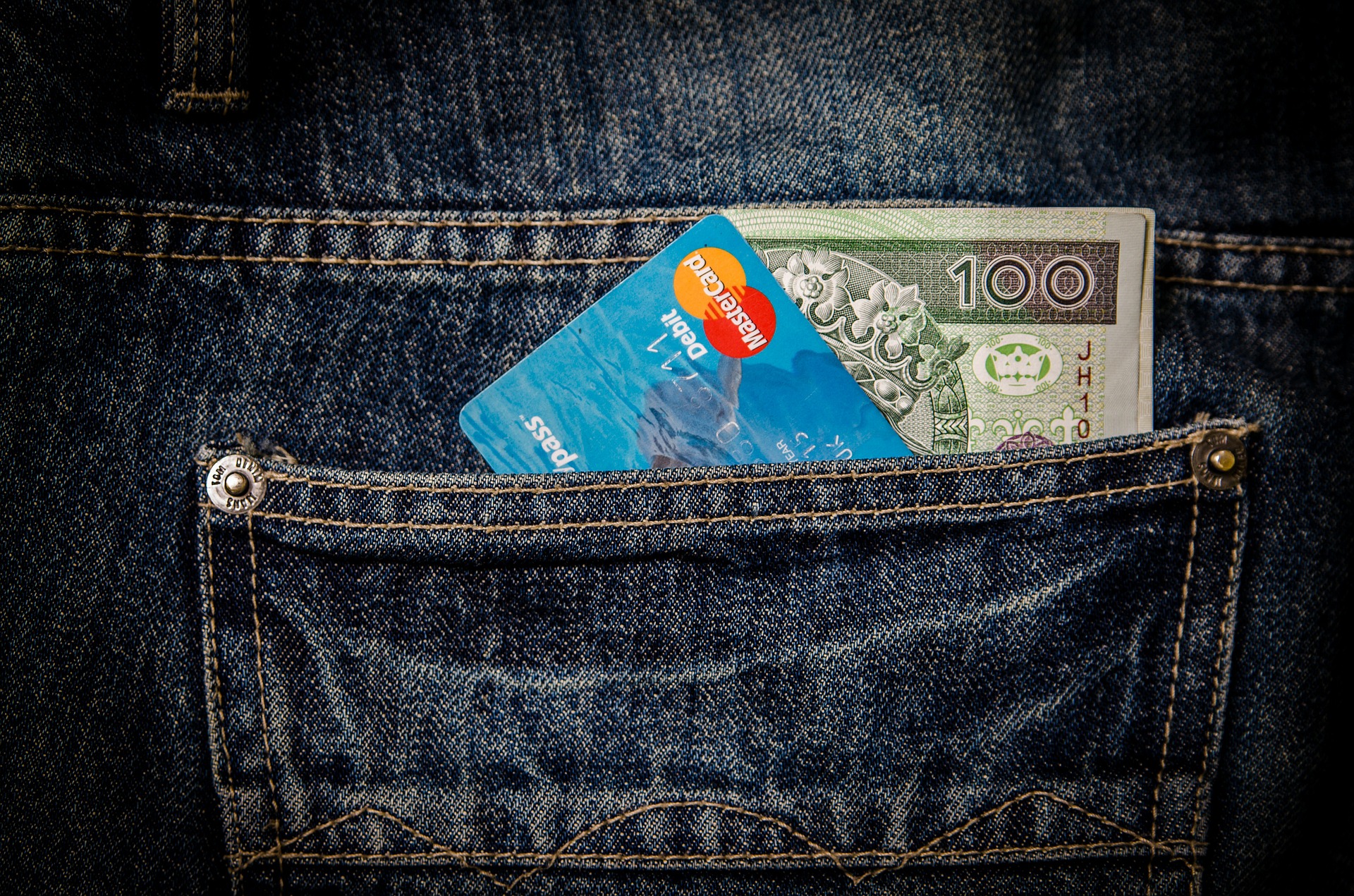 Kreditkarte und Bargeld in der Hosentasche