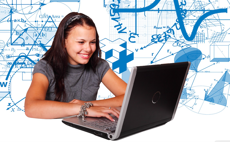 lächelndes Mädchen vor Laptop mit mathematischen Formeln im Hintergrund
