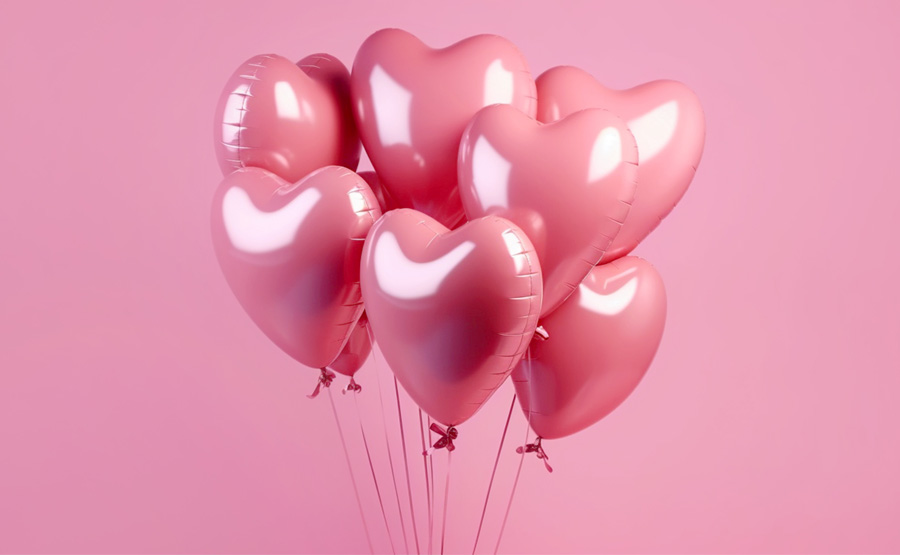 rosafarbene Herzluftballons vor einem rosa Hintergrund